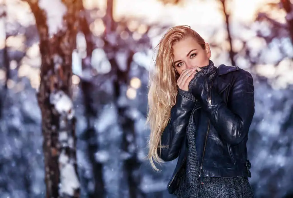 female wearing stylish leather jacket in winter park