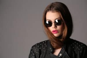 Lady in a studded leather jacket and circle sunglasses