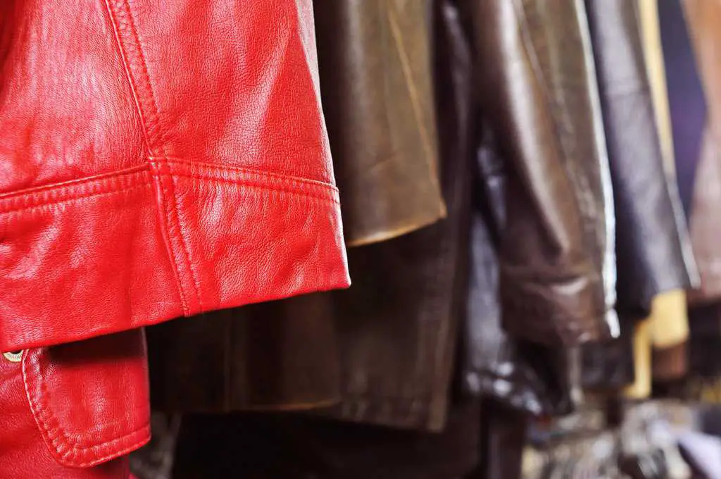 leather jackets hanging on a rack at a thrift store