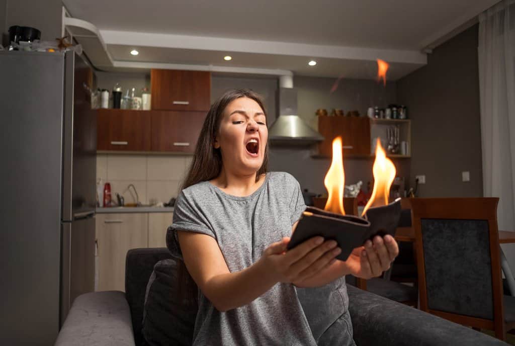 young woman holding leather wallet on fire